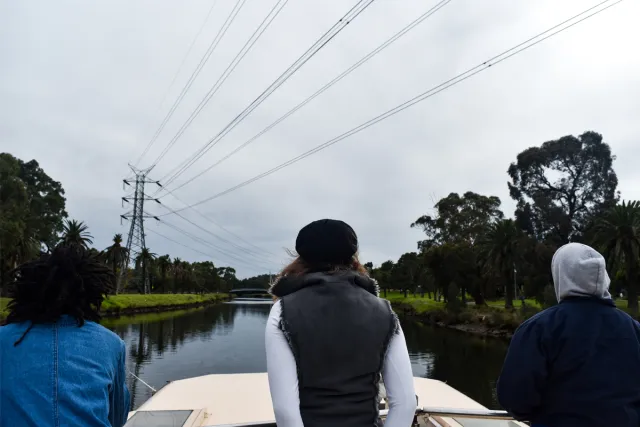 Three participants looking out over the river from the top of the Tramboat